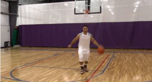 球员压低重心，左手持球佯装向左突破，头部和肩部剧烈晃动，眼神看向左侧底角，随后猛地将球拉回右侧，如离弦之箭般从防守者身侧切入。