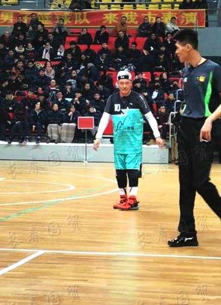 身穿红色球衣的赵本山老师在场上运球突破，眼神专注，动作矫健，面对防守者毫无惧色