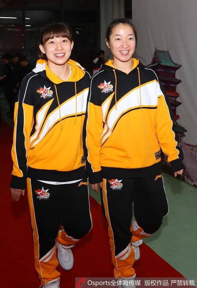 夺得三分大赛冠军的金佳宝高举冠军奖杯，脸上绽放出灿烂而自信的笑容，她身后的灯光映照出这位神射手的荣耀时刻。