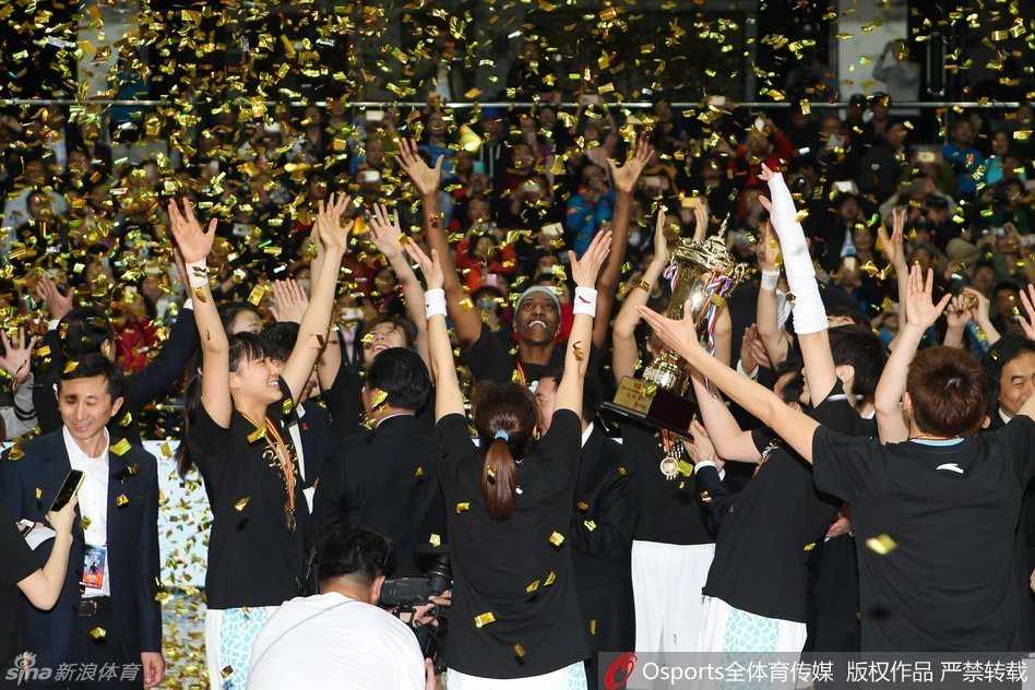 首钢篮球中心漫天金雨纷飞而下，北京女篮众将身披金色绶带战袍，簇拥在一起捧起那座象征最高荣耀的WCBA总冠军鼎，笑容比场馆的灯光更加璀璨夺目。