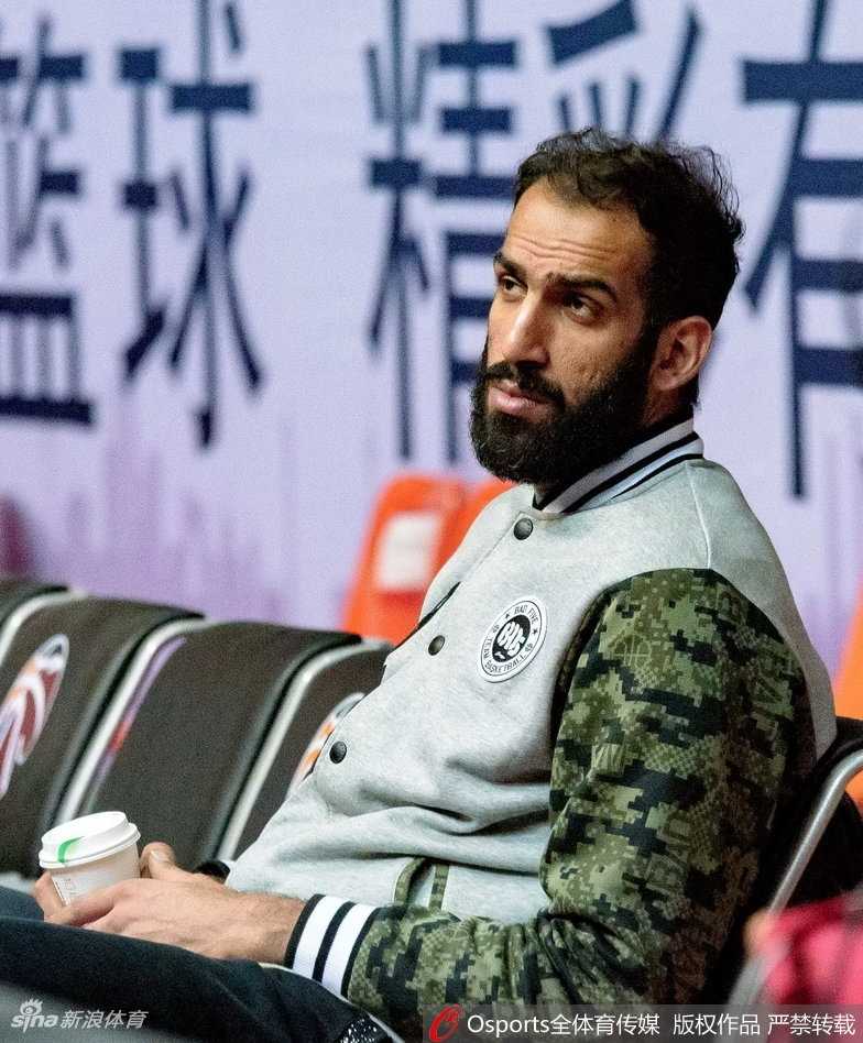 蜀道难·巨人擎天:哈达迪热饮暖身引领四川金强寒夜逆袭 哈达迪与队友在场边交流,他紧握冒着热气的杯子,身旁的年轻球员认真聆听这位老大哥的指点。