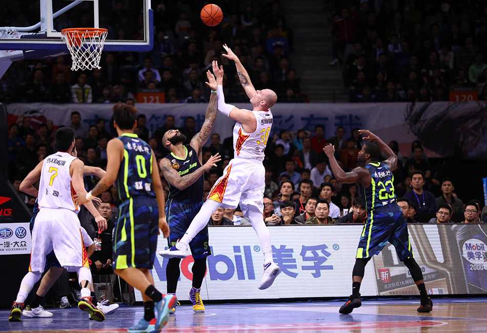 易建联背身单打瞬间，他沉肩发力顶开防守人，双手持球高高跃起，整个身体在空中完全舒展，准备完成一记势大力沉的暴扣