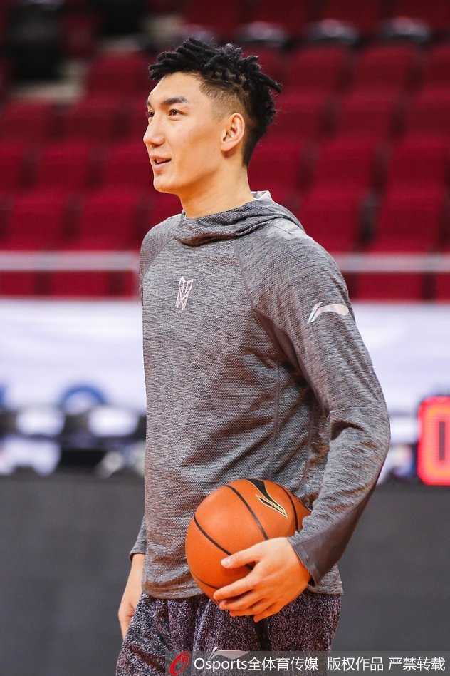 训练间歇，西热力江在场边大口喝水补充能量，汗如雨下，眼神中透露出不服输的倔强与坚韧