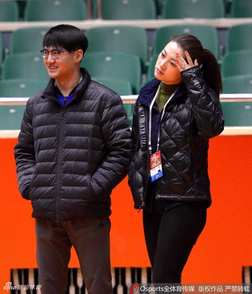 赛场背后探营记:美女记者直击新疆广汇与山东高速男篮高强度备战 在训练结束后的场边,美女记者将话筒递向一位浑身湿透的新疆队主力球员,两人面带微笑进行着赛后简短的交流,背景是空旷的看台和整理器材的助理教练,氛围轻松而专业。