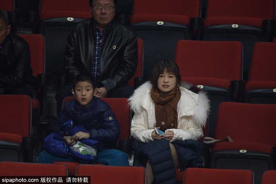 看台上的美女观众不经意间成为了镜头的焦点，她戴着标志性的圆框眼镜，面庞清秀，在略显昏暗的观众席中显得格外醒目，眼神中流露出对比赛的专注与好奇。