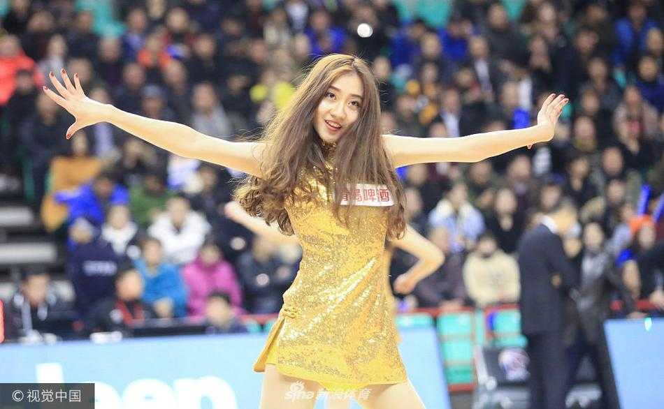 在动感的音乐节奏中，一位舞娘秀发飞扬，她身着裁剪利落的金色短裙，以极具张力的舞姿展现出属于篮球宝贝的独特魅力。