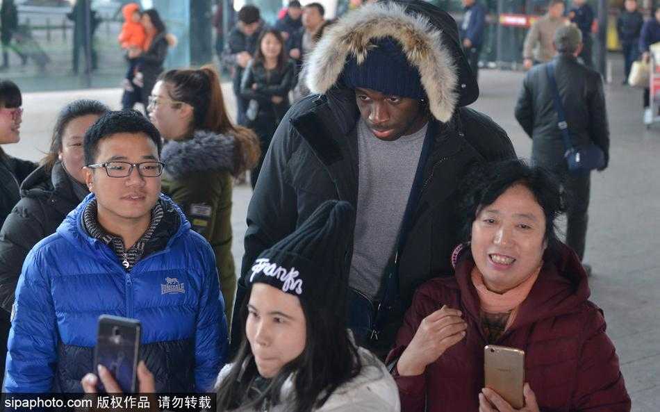 在安保人员的护送下，郭艾伦艰难地向前移动，但始终面带微笑回应着两侧热情的呼唤。