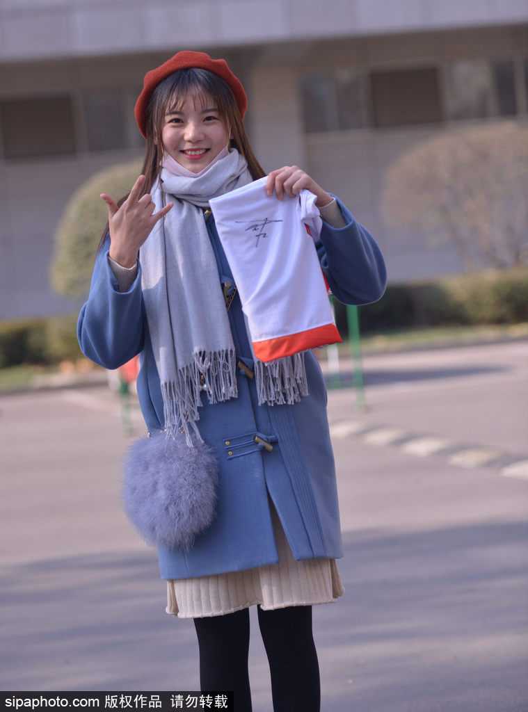 迷妹的漫长等候,只为CBA赛场外的那份真情 一位短发女球迷双手捧着篮球和照片,神情专注而紧张地望着球员通道,仿佛下一秒她的偶像就会出现,完成她期待已久的签名。