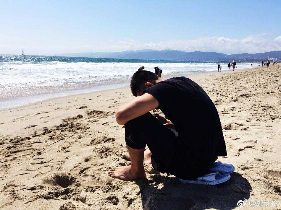 郭艾伦眯眼对着手机镜头咧嘴笑，背后是洛杉矶威尼斯海滩的碧海蓝天，金色阳光洒在他小麦色的皮肤上，像个大男孩一样惬意