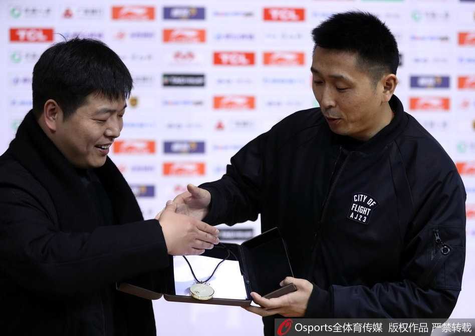 金镶玉寄深情:球迷匠心赠礼致敬胡雪峰传奇生涯 赛前这一温馨的赠礼环节,让全场气氛达到高潮,胡雪峰手持话筒似乎在说着感谢的话,而背景中江苏德比的大战氛围已一触即发。