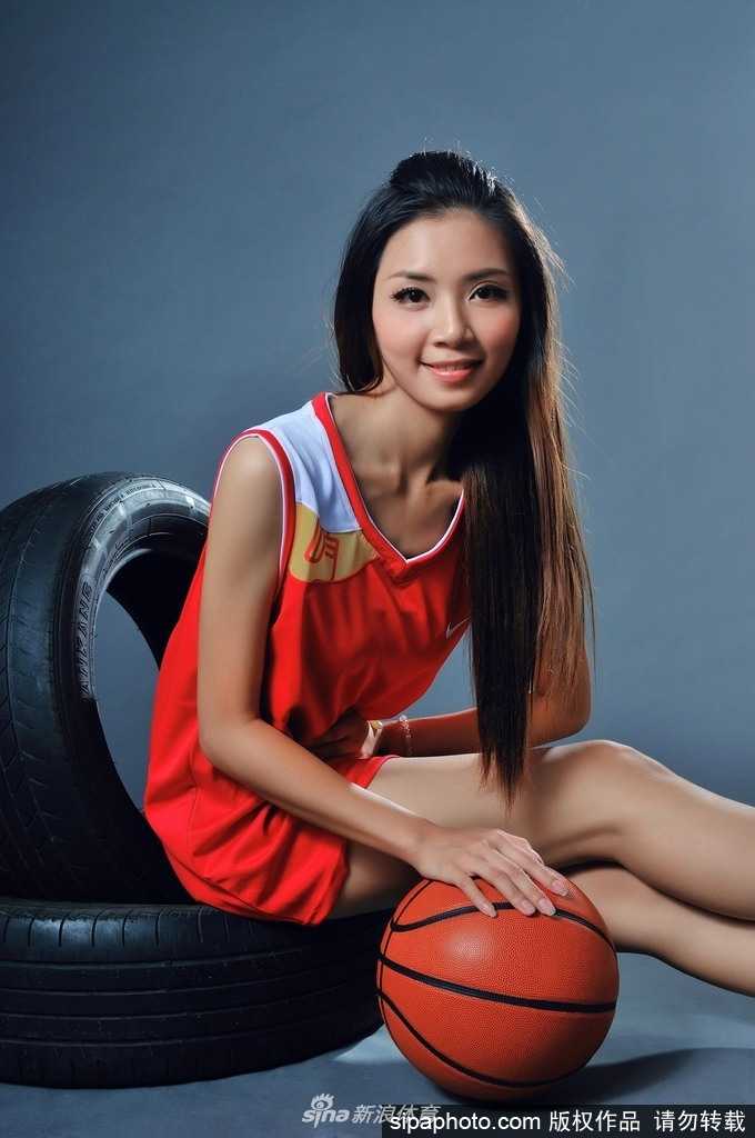 钟苑庄侧身站立，双手抱球高举过头，身体曲线在球场光线下显得健美而修长