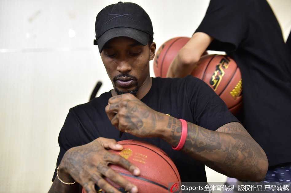 斯科拉在互动环节亲自上阵指导五中篮球队的小队员，他弯下腰耐心地比划着篮下进攻的跑位路线，眼神专注而温和，身旁的年轻球员们听得聚精会神。