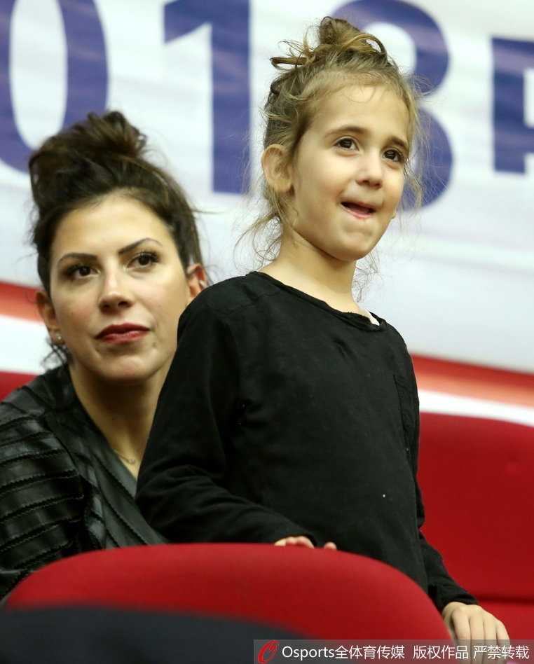 铁汉柔情:希腊中锋博洛西斯的篮球征途与场边最暖注视 博洛西斯妻子抱着女儿在场边观战,她们穿着温馨的便装,在嘈杂的球馆中为场上的家人默默祈祷。