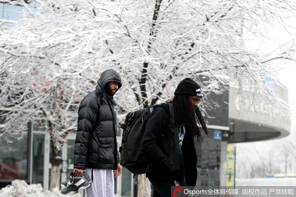 广厦球员胡金秋在乌鲁木齐大雪中露出灿烂笑容，身后的街景已被白雪覆盖，南方少见的大雪让他显得格外兴奋。