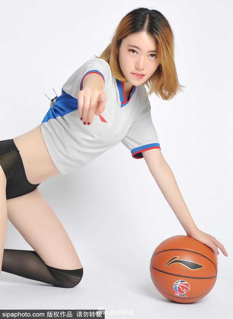 聚光灯下，一位篮球宝贝身穿亮黄色表演服，回眸凝视，展现出赛场上的自信与灵动之美。