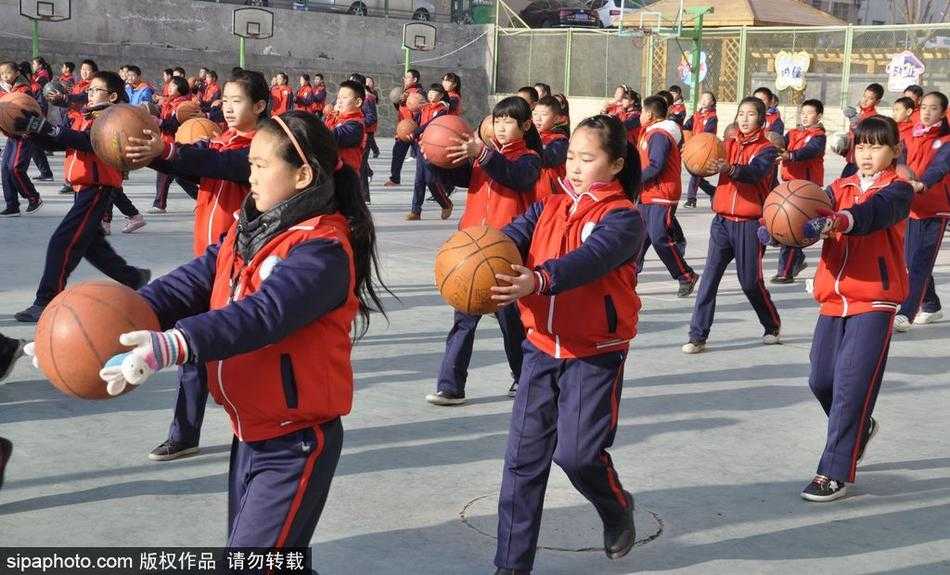 表演接近尾声，孩子们高高举起手中的篮球，组成一片壮观的“球林”。在蓝天和教学楼的映衬下，无数个橙色的篮球仿佛一个个升腾而起的梦想，为这场精彩的篮球操画上了一个圆满而充满希望的句号。