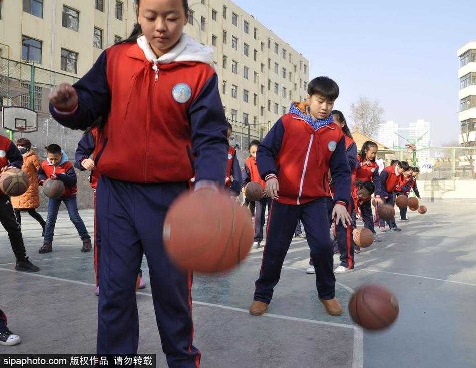 特写镜头下，一名小男孩目光如炬，紧紧盯着手中旋转的篮球。他身体半蹲，姿势标准，小小的手掌仿佛有魔力一般，将篮球牢牢控制在指尖，专注的神情里透着一股不服输的韧劲。