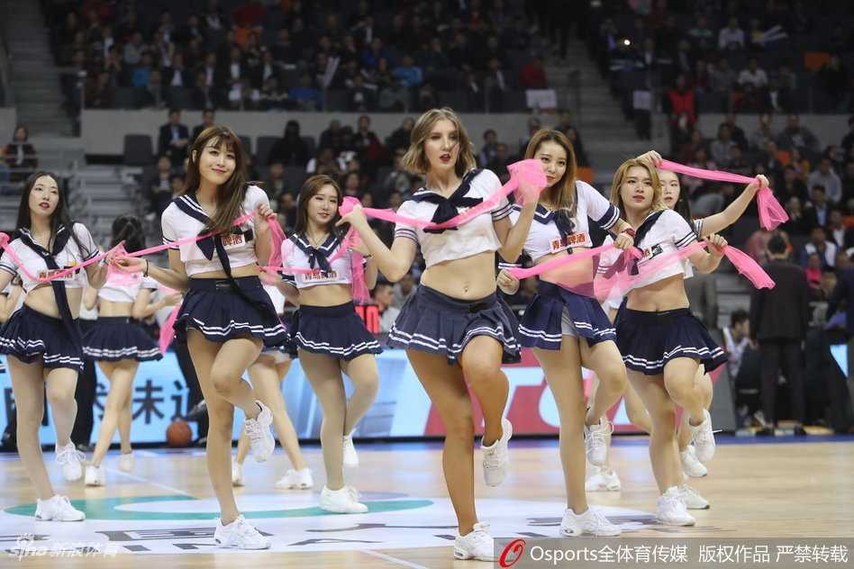 青春风暴席卷赛场,广东男篮啦啦队学生服演绎清纯与活力 近景画面中,领舞的队员笑容甜美,手中舞动着彩色花球,学生服的深色领带与白色衬衫形成鲜明对比,将少女的活力与优雅平衡得恰到好处。