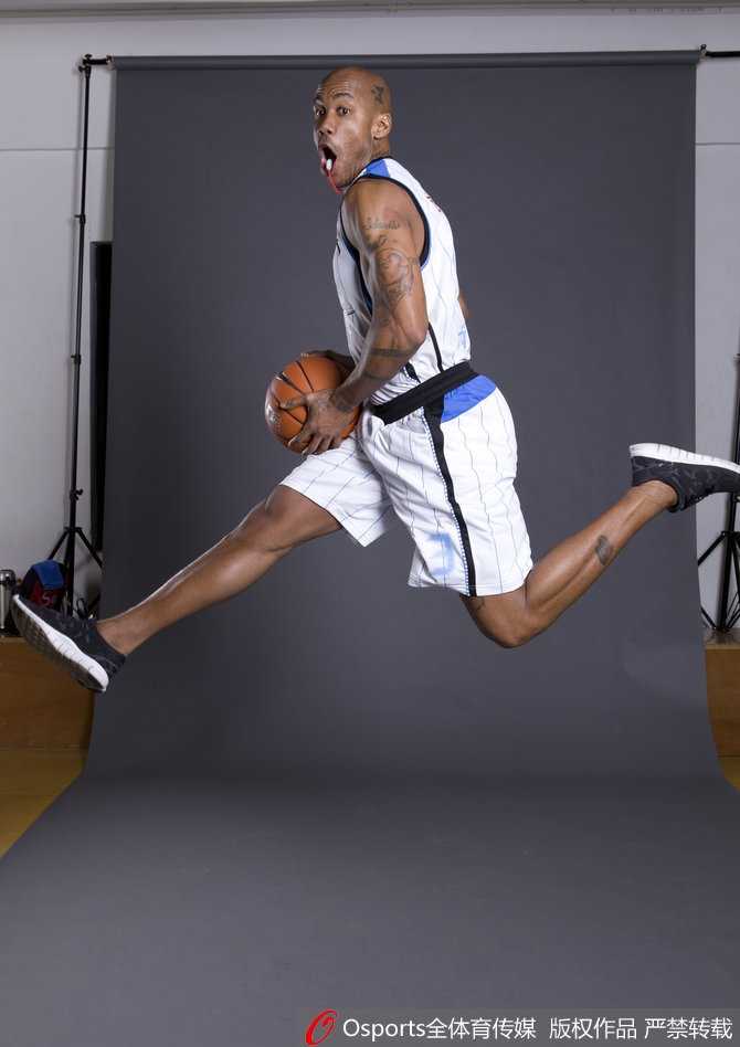 马布里与一群北京孩子在一起，他弯下腰，亲切地拍着一个孩子的头，孩子们围着他笑逐颜开，画面温暖动人，传递着篮球未来的希望。