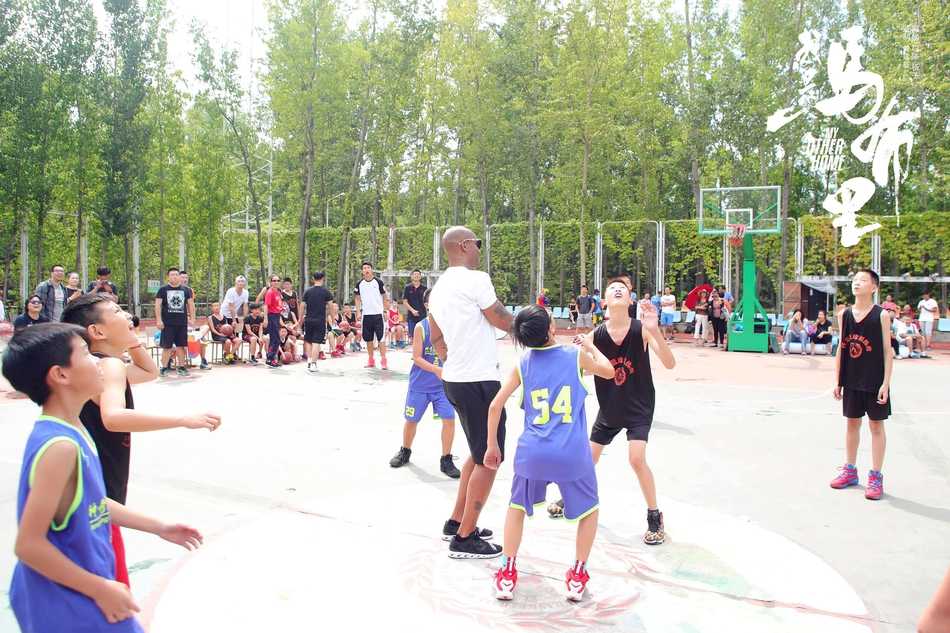 在球场上，一名勇敢的小学生正试图突破马布里的防守，老马则张开双臂，作出认真防守的姿态，场面既温馨又充满竞技的趣味。