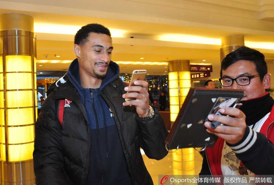 齐鲁烽火再燃:广东宏远众将兵临济南,山东球迷热情相迎 球员通道内,广东队工作人员正忙碌地搬运着沉重的装备箱,背景是灯光璀璨的球馆入口,预示着大战一触即发,每个细节都透着紧张与秩序。