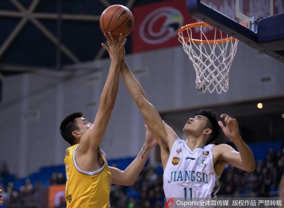 广厦队胡金秋在江苏队两人夹击的缝隙中，用一记柔和的手感完成抛投，眼神专注于篮筐，展现了“中国字母哥”的灵动与天赋。