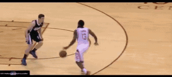 球员眼神看向一侧队友，单手做出传球的假动作，下一秒却迅速收球，双脚如螃蟹般横向拉开，轻松过掉防守者。